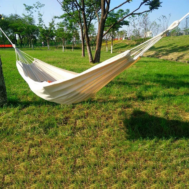 Hammock hung between two trees in a garden